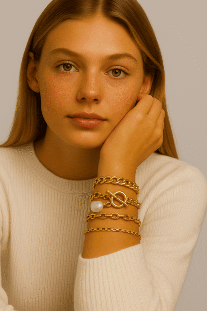 Bracelets en or avec perle et fermoir bola, élégant et tendance, parfaits pour la mode féminine, porté par une femme avec pull blanc, style chic et sophistiqué.