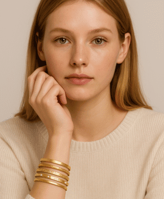 Bracelets en or rose, multirang et minimaliste, portés par une femme avec une peau claire et des cheveux roux, parfaits pour accessoiriser une tenue élégante ou décontractée.