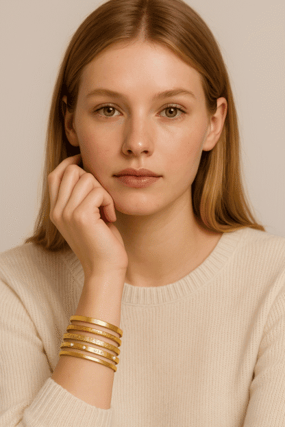 Bracelets en or rose, multirang et minimaliste, portés par une femme avec une peau claire et des cheveux roux, parfaits pour accessoiriser une tenue élégante ou décontractée.