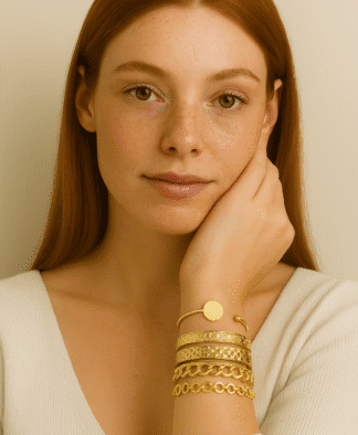 Bracelet en or doré avec motifs torsadés et chaînes élégantes, porté par une femme aux cheveux roux et à la peau claire, pour une touche sophistiquée et tendance.