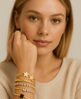 Bracelet en or, joncs et chaînes avec étoiles, pierres blanches, noir et transparents pour un look chic et féminin.