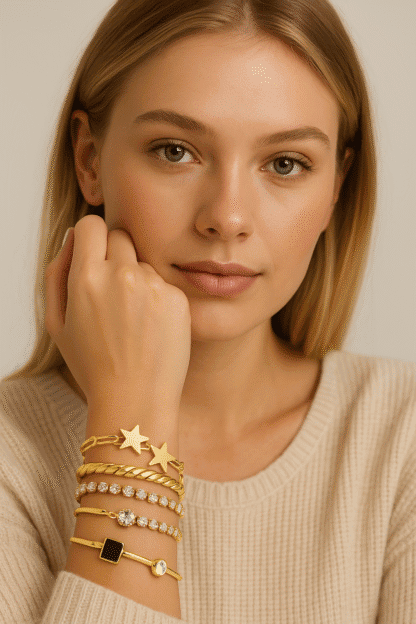 Bracelet en or, joncs et chaînes avec étoiles, pierres blanches, noir et transparents pour un look chic et féminin.