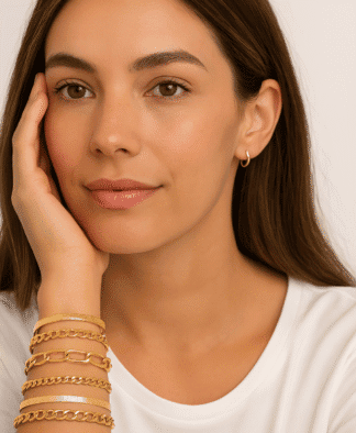 Brune femme élégante portant des boucles d'oreilles en or, avec plusieurs bracelets en or tendance et délicats, mettant en valeur un style chic et sophistiqué, idéal pour la mode bijou.[Relevancy: pertinent, mettant en avant des bijoux en or dans un contexte de mode.].