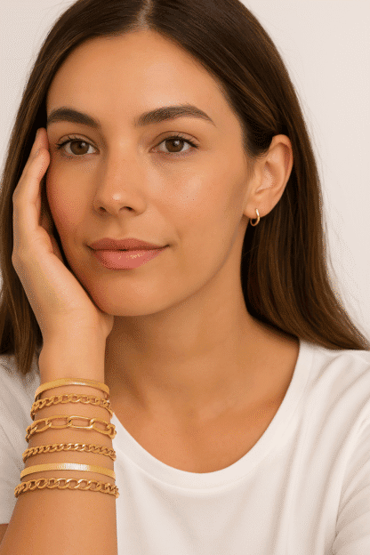 Brune femme élégante portant des boucles d'oreilles en or, avec plusieurs bracelets en or tendance et délicats, mettant en valeur un style chic et sophistiqué, idéal pour la mode bijou.[Relevancy: pertinent, mettant en avant des bijoux en or dans un contexte de mode.].