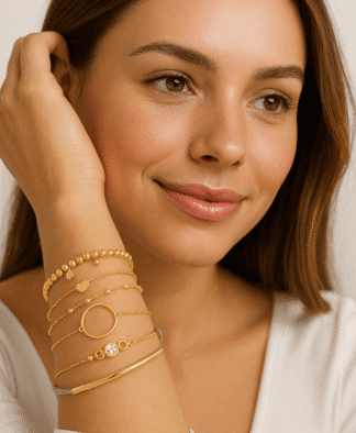 Bracelets en or pour femmes avec pendentifs et pierres de zircon, montrant élégance et style délicat, portés sur le bras d'une femme avec un maquillage naturel et un sourire subtil.