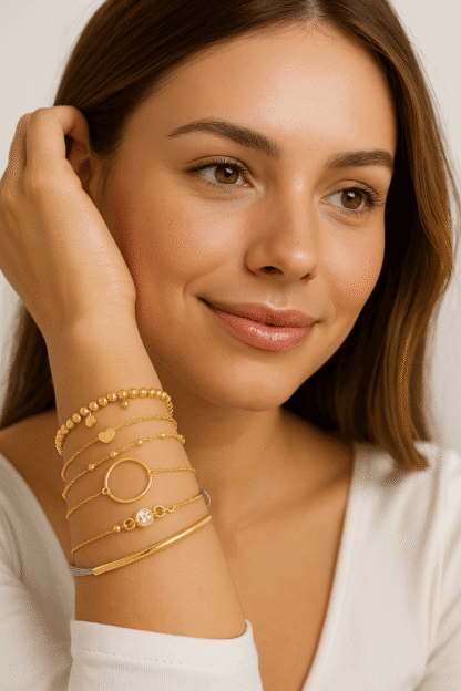 Bracelets en or pour femmes avec pendentifs et pierres de zircon, montrant élégance et style délicat, portés sur le bras d'une femme avec un maquillage naturel et un sourire subtil.