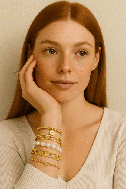 Bracelets en or et perles, style élégant et tendance, porté par une femme avec peau claire et cheveux roux. Accessoires parfaits pour un look chic et sophistiqué.